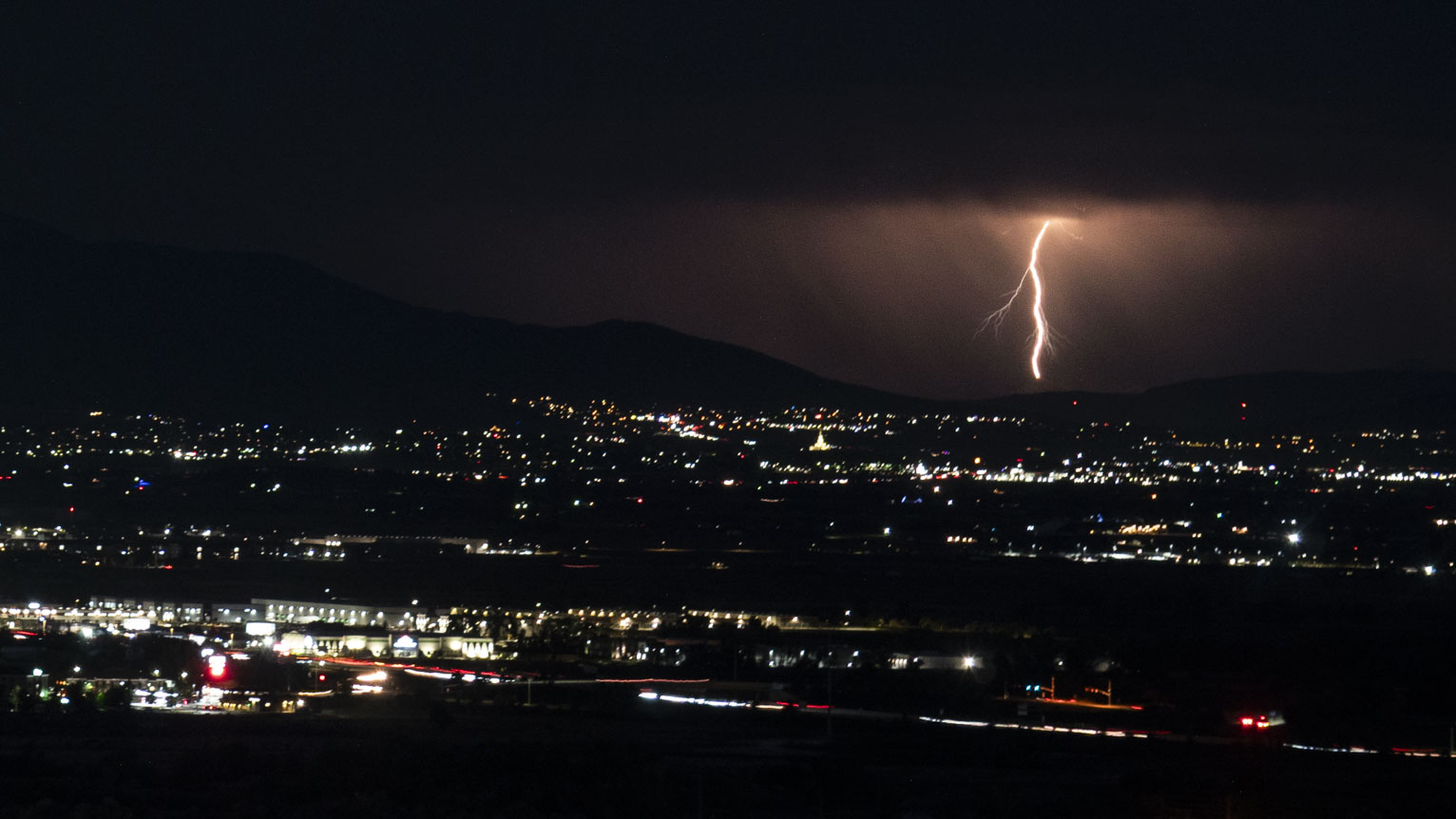 An orangey yellow bolt reaches all the way to the ground and almost seems to be twirling